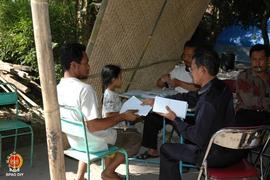 Seorang warga korban gempa bumi bersama anaknya sedang menerima bantuan jatah hidup yang dilakuka...