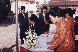 Para tamu undangan (anggota DPRD DIY) sedang mengisi daftar hadir di depan ibu-ibu panitia penyam...