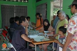 Seorang ibu sedang memegang amplop setelah menerima jatah hidup bagi korban gempa sambil memegang...