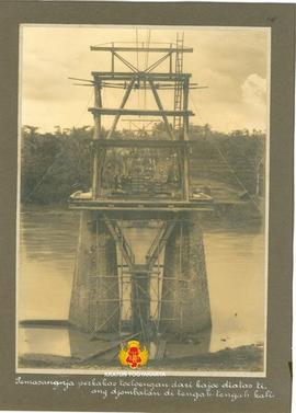 Tiang jembatan dipasang perkakas tulungan (semacam steiger) dari kayu di atas tiang jembatan di b...