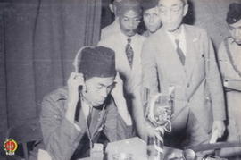 Panglima Besar Jenderal Soedirman sedang mencoba Radio Telepon, dengan melakukan siaran .